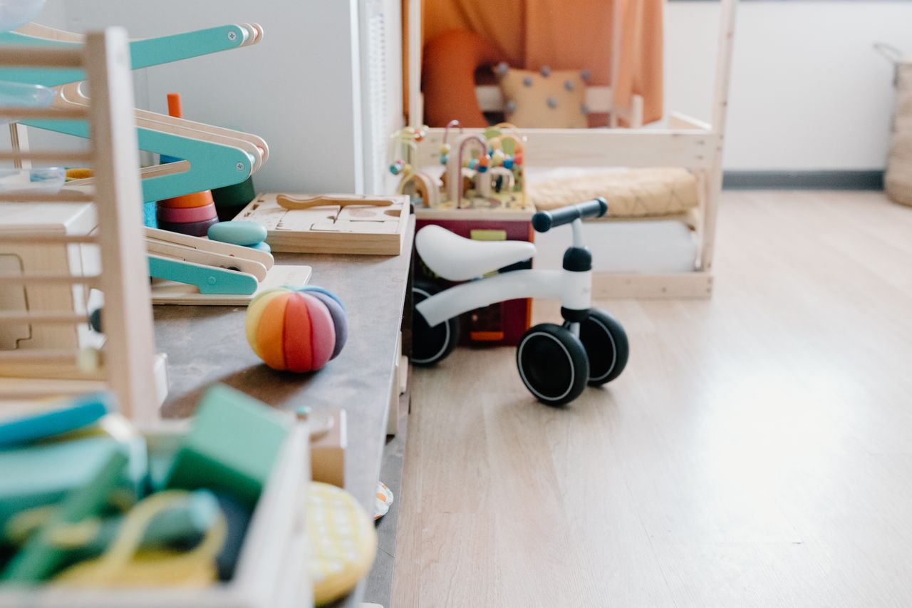 Bright and minimalistic children's playroom featuring wooden toys and balance bike for sustainable learning.
